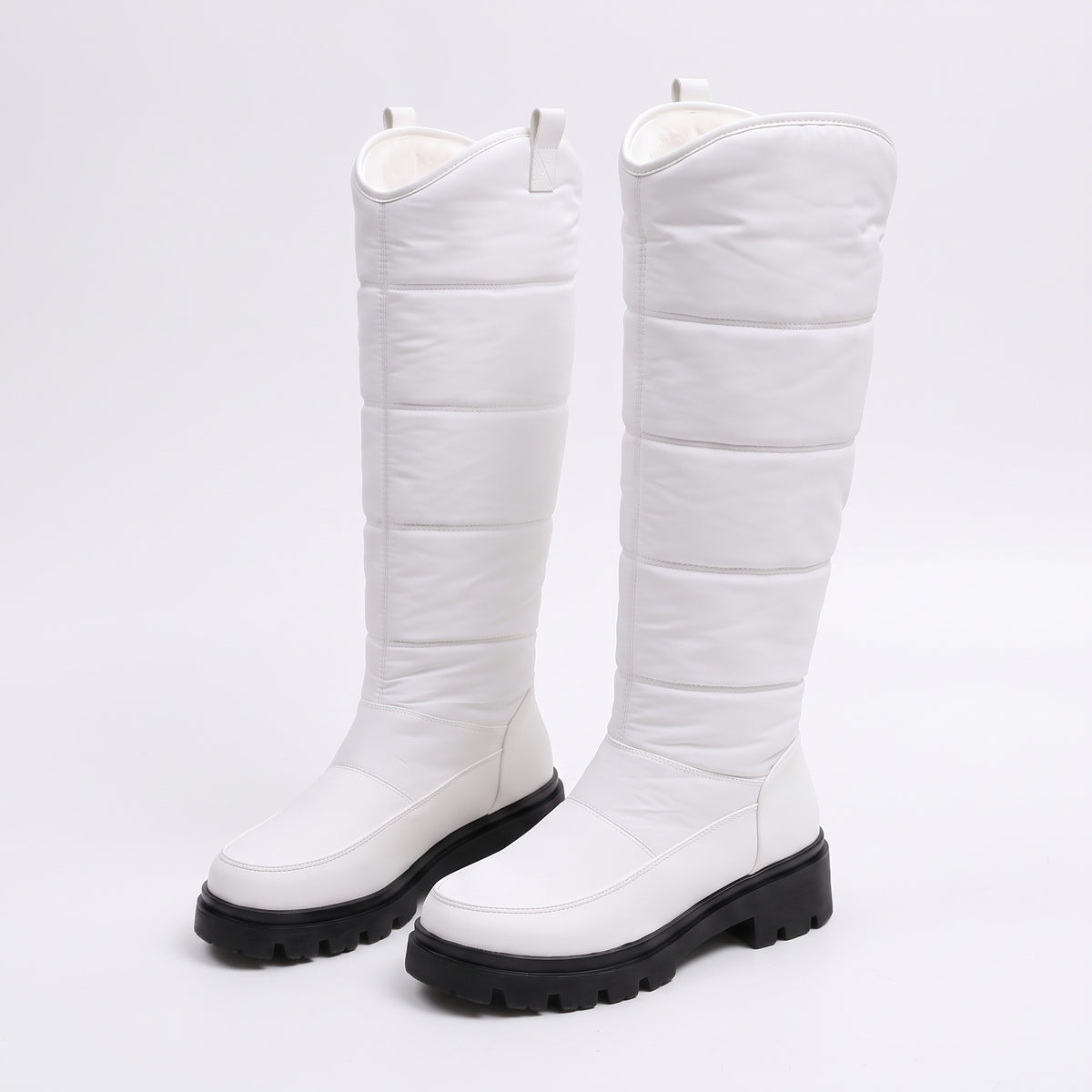 Buty zimowe damskie w kolorze białym z pikowaną cholewką i czarną podeszwą na białym tle
