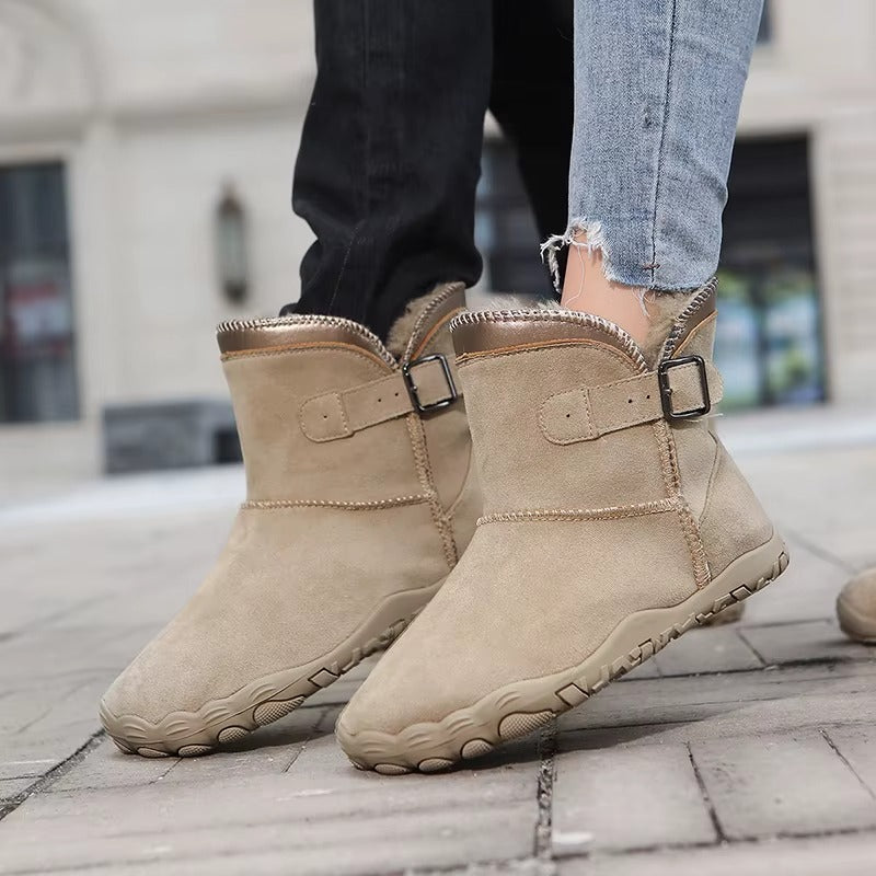 Śniegowce barefoot w kolorze piaskowego beżu na nogach na chodniku