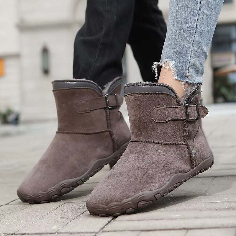 Śniegowce barefoot w kolorze szarobrązowym na nogach na chodniku